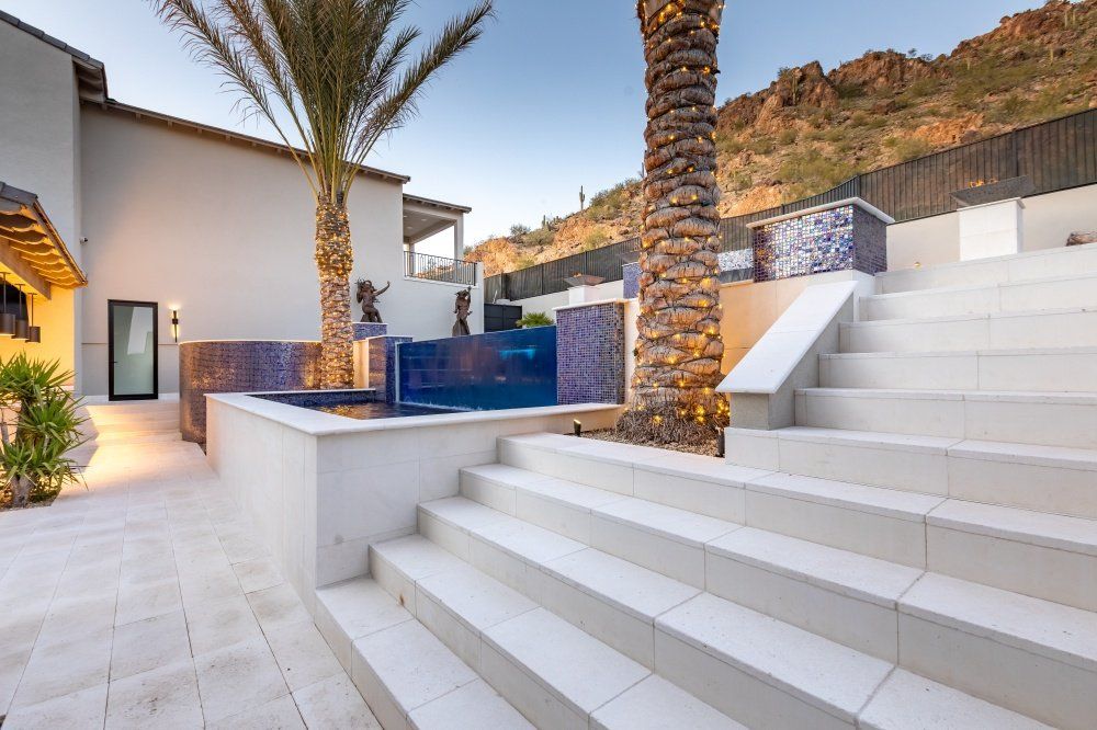 A staircase leading up to a swimming pool with a palm tree in the background.
