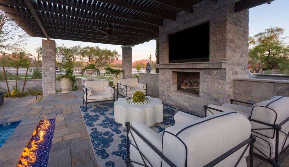 A patio with a fireplace and a flat screen tv