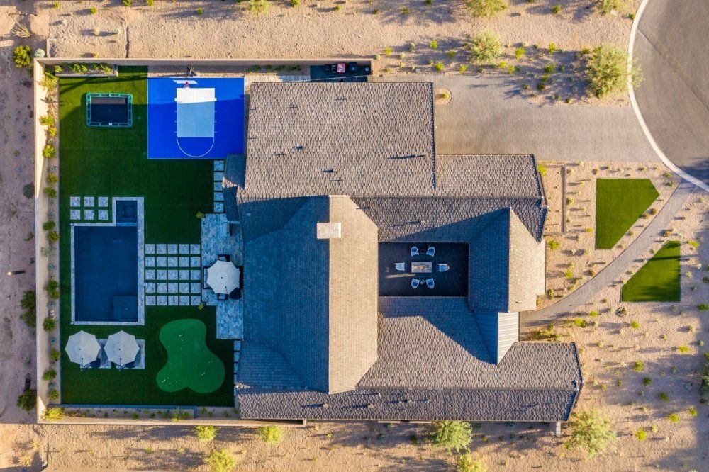 An aerial view of a house with a pool and a playground.