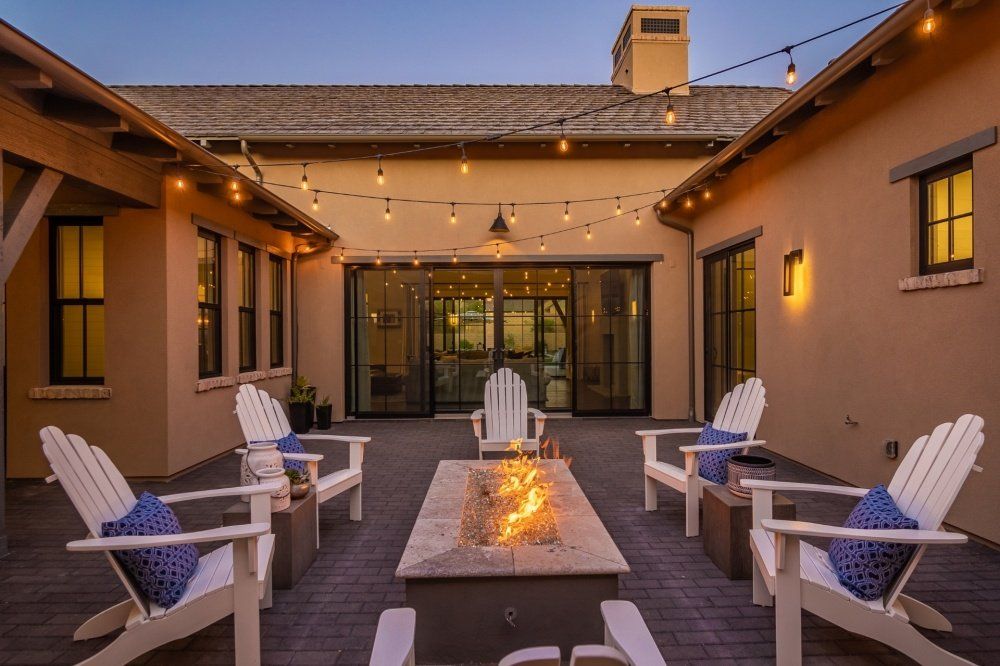 There is a fire pit in the middle of the courtyard surrounded by chairs.