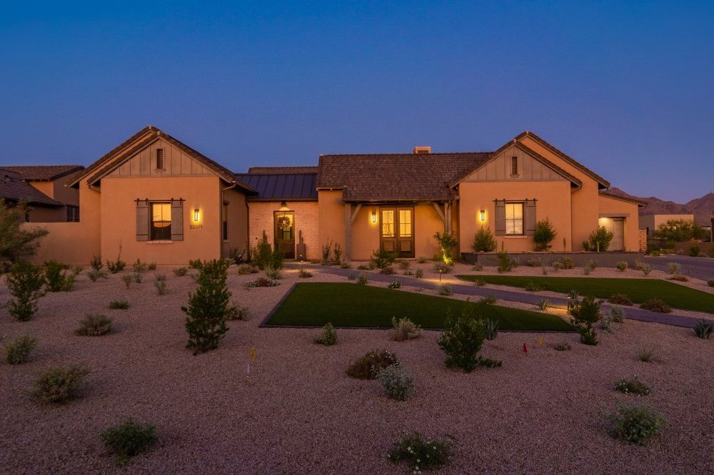 A large house is lit up at night in the desert.