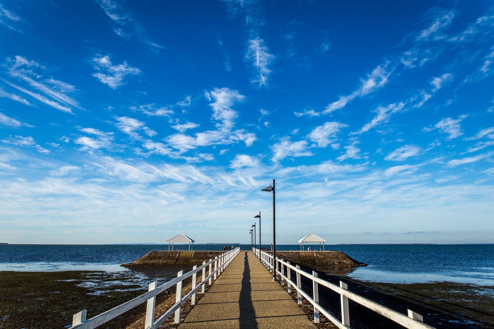 Mt Gravatt mall with various shops and a large sign on a sunny day.
