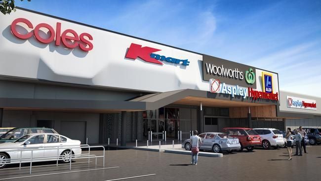 Carindale Westfield shopping center exterior with signs for various stores. Cars on road and in parking.