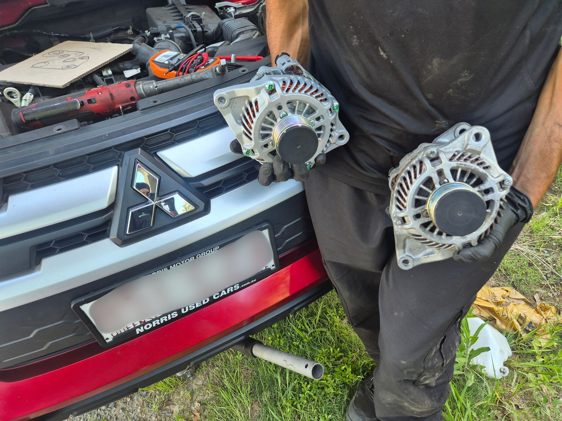 Mechanic checking engine oil level with a dipstick in a car engine compartment.
