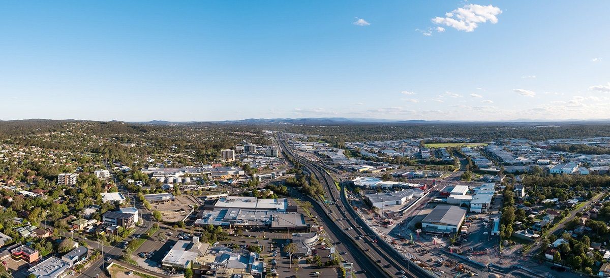 Aerial view of Logan with a highway running through it, under a blue sky.