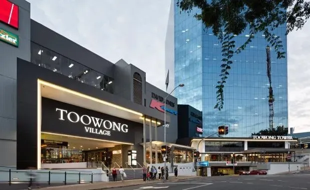 Toowong Village shopping center entrance with tall glass building in the background.