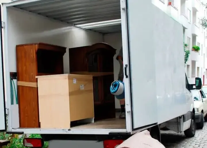 Camión de mudanzas con muebles cargados en su interior.