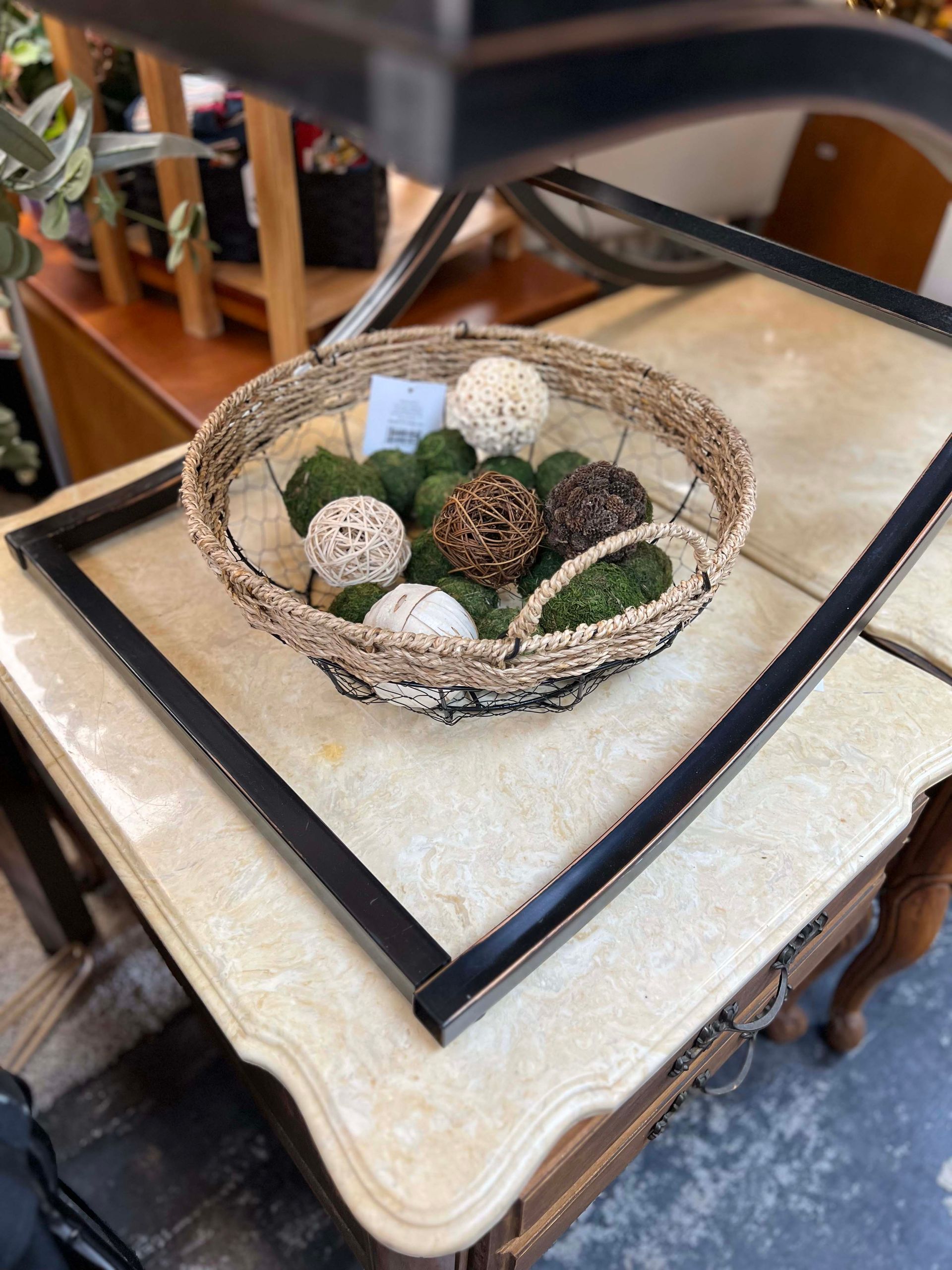 A basket of balls is sitting on top of a table.