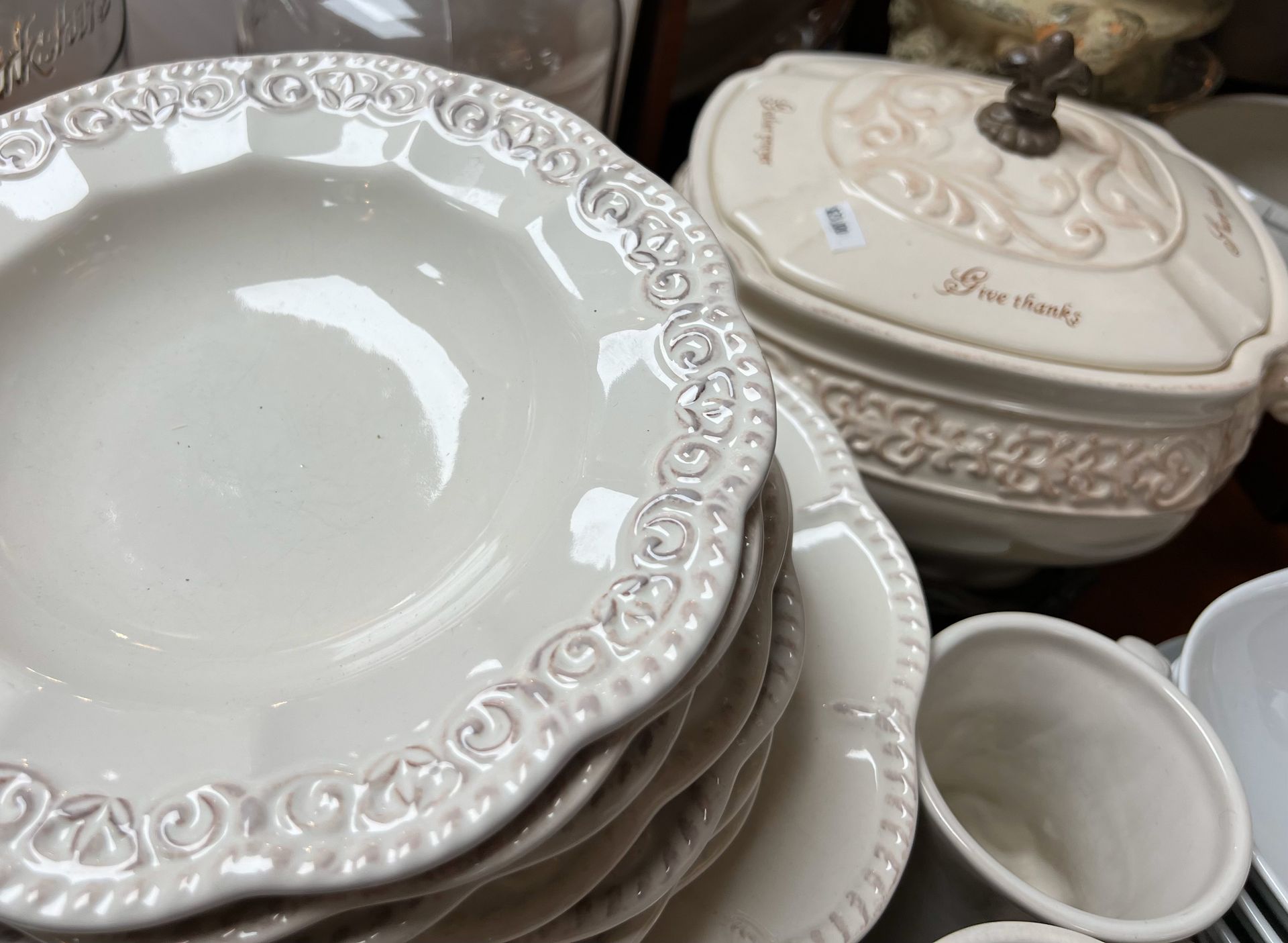 A stack of white plates sits next to a bowl that says free country