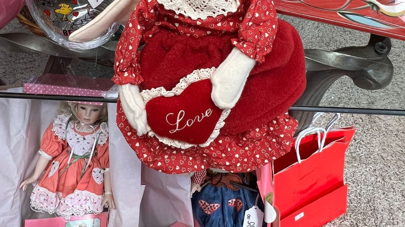 A doll holding a heart that says love on it