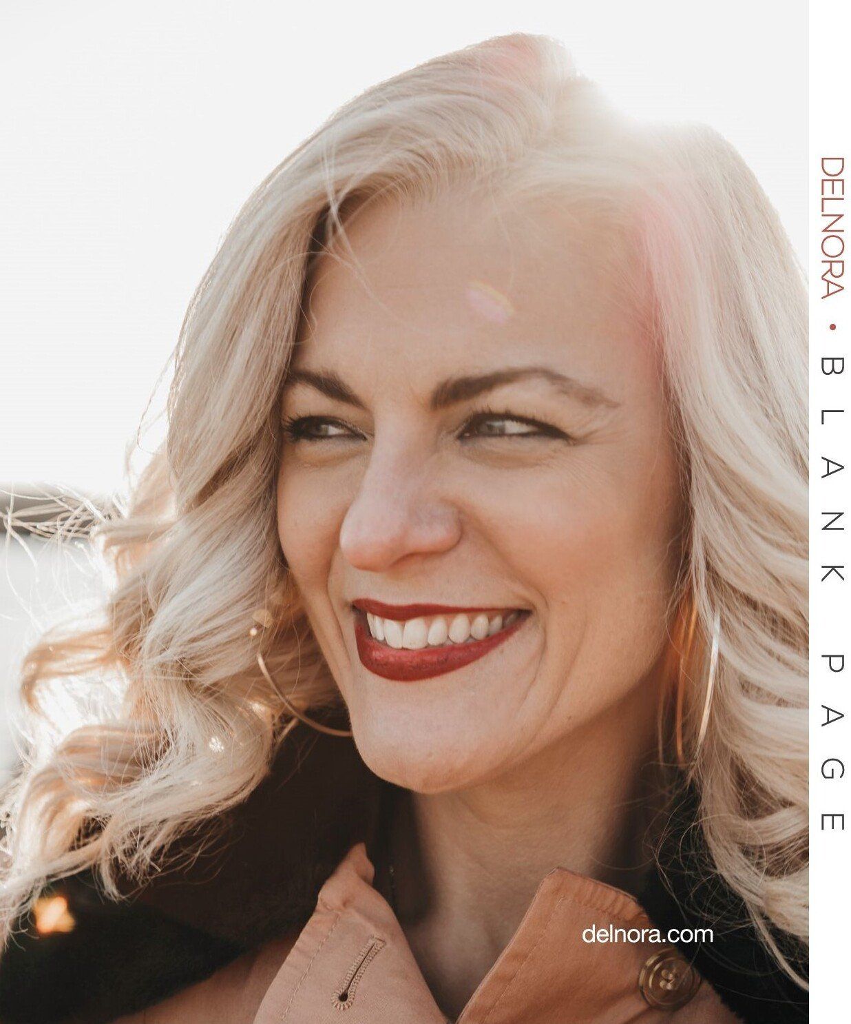 A woman with blonde hair and red lipstick is smiling.