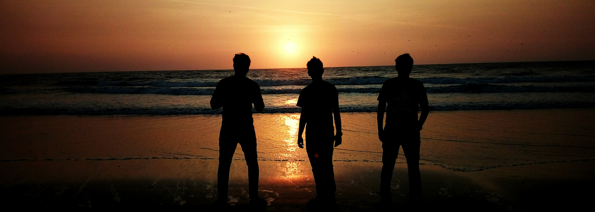 Picture of a group of people standing on quiet part of a beach.