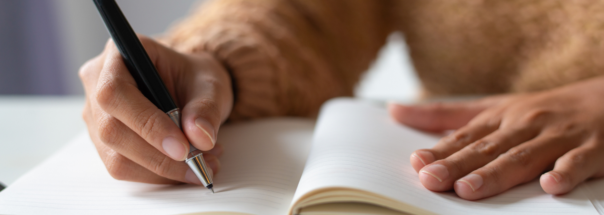 Picture of someone writing in a book. Picture of someone writing in a book.