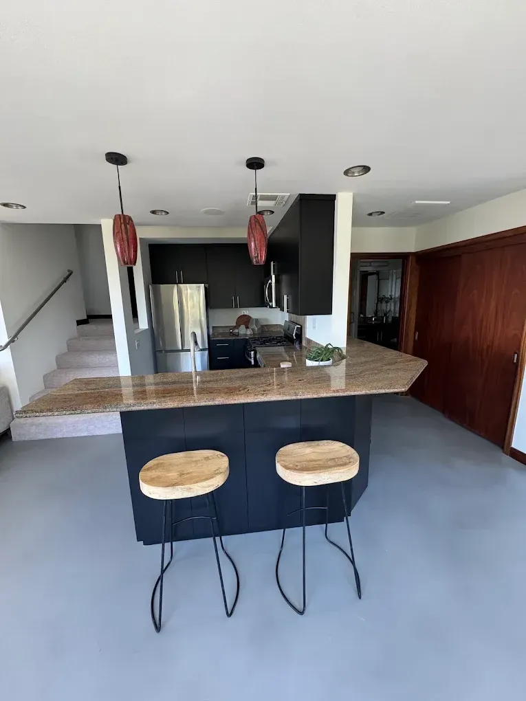 A kitchen with a large island and two stools