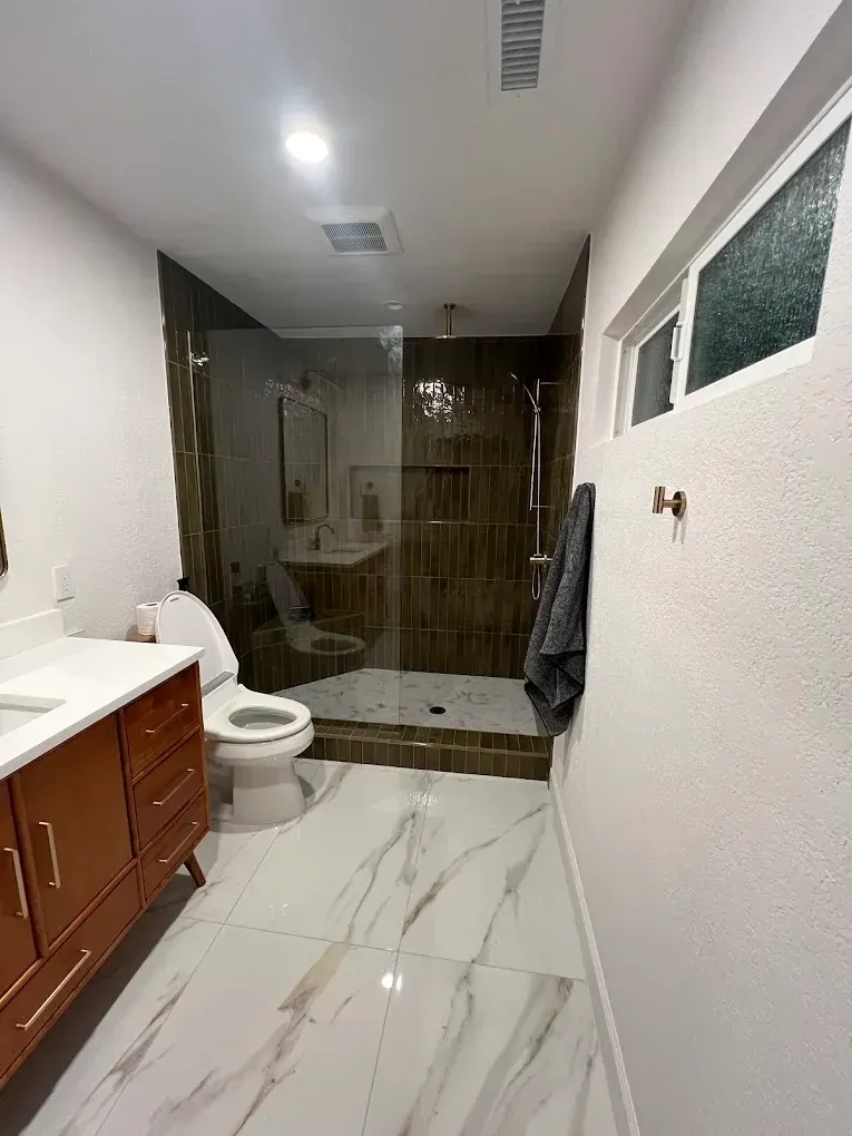 A bathroom with a toilet , sink , and walk in shower.