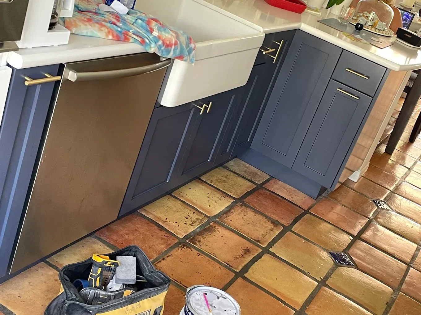 A kitchen with blue cabinets and a stainless steel dishwasher.