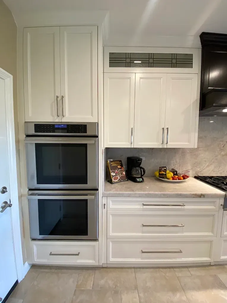 A kitchen with white cabinets and stainless steel appliances.