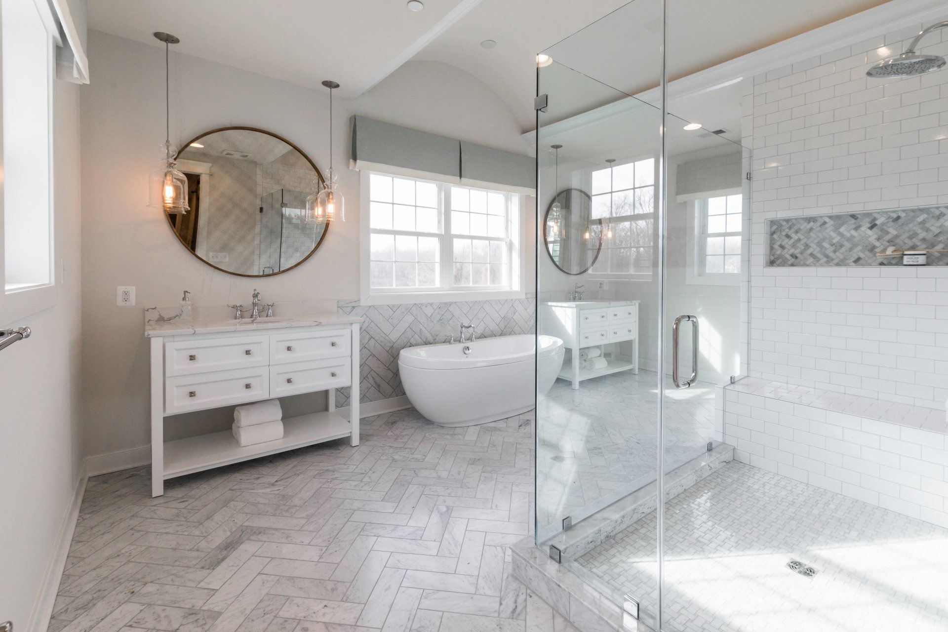 Elegant white bathroom with a glass shower, soaking tub, and marble accents.