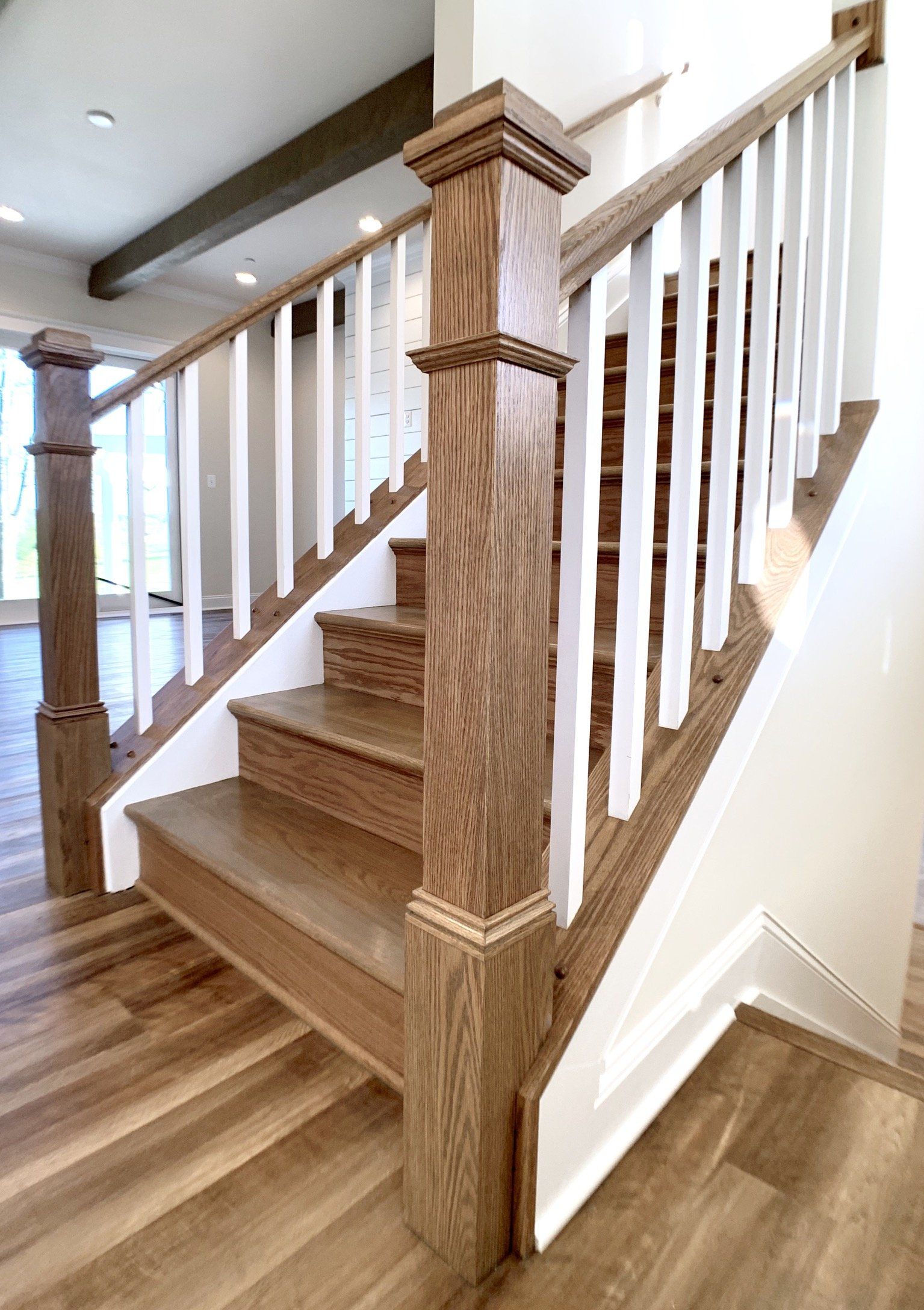 Wooden staircase with white spindles, oak handrails and posts.