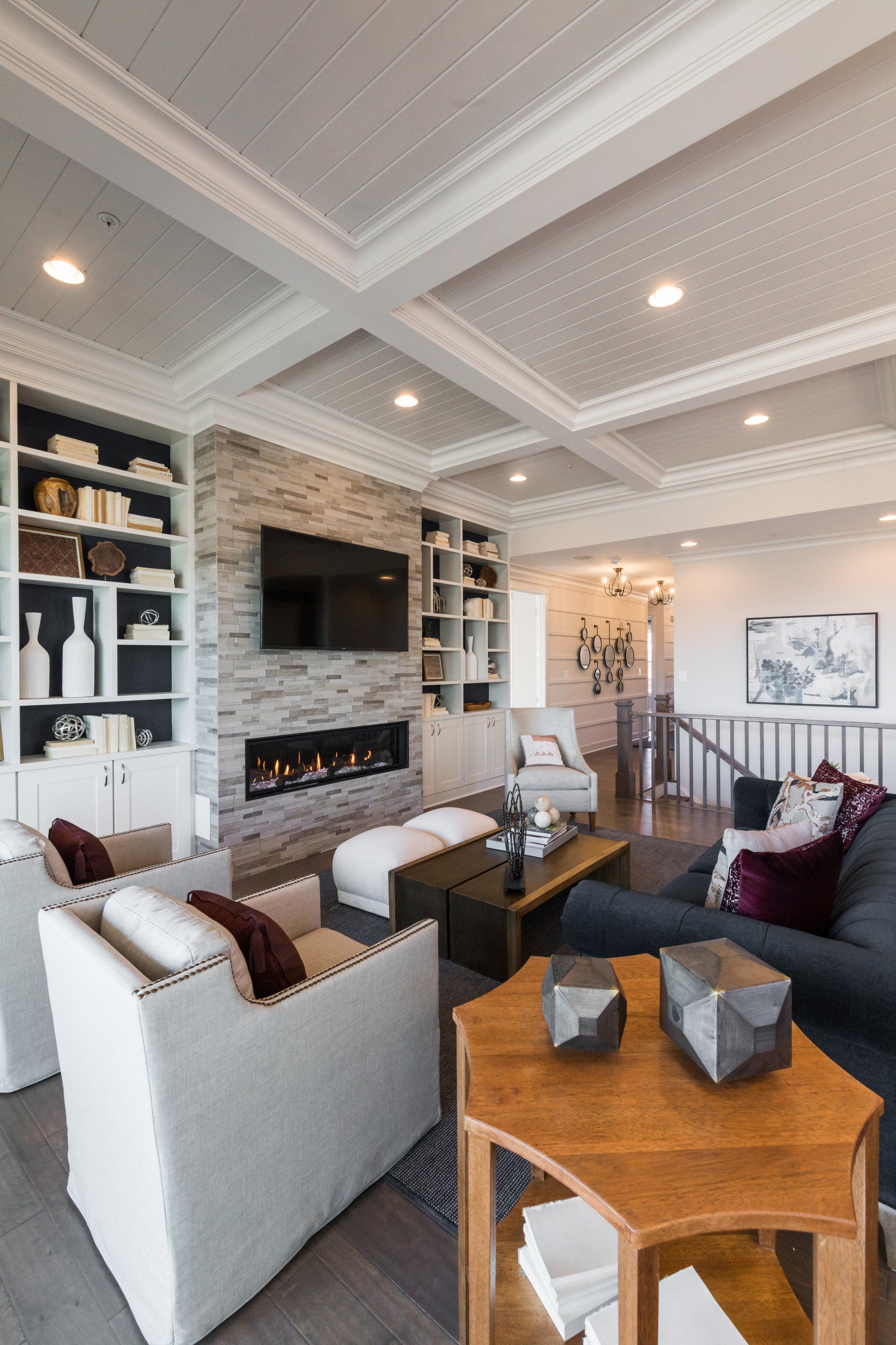 Living room with white ceiling, fireplace, gray sofa, and two white armchairs.