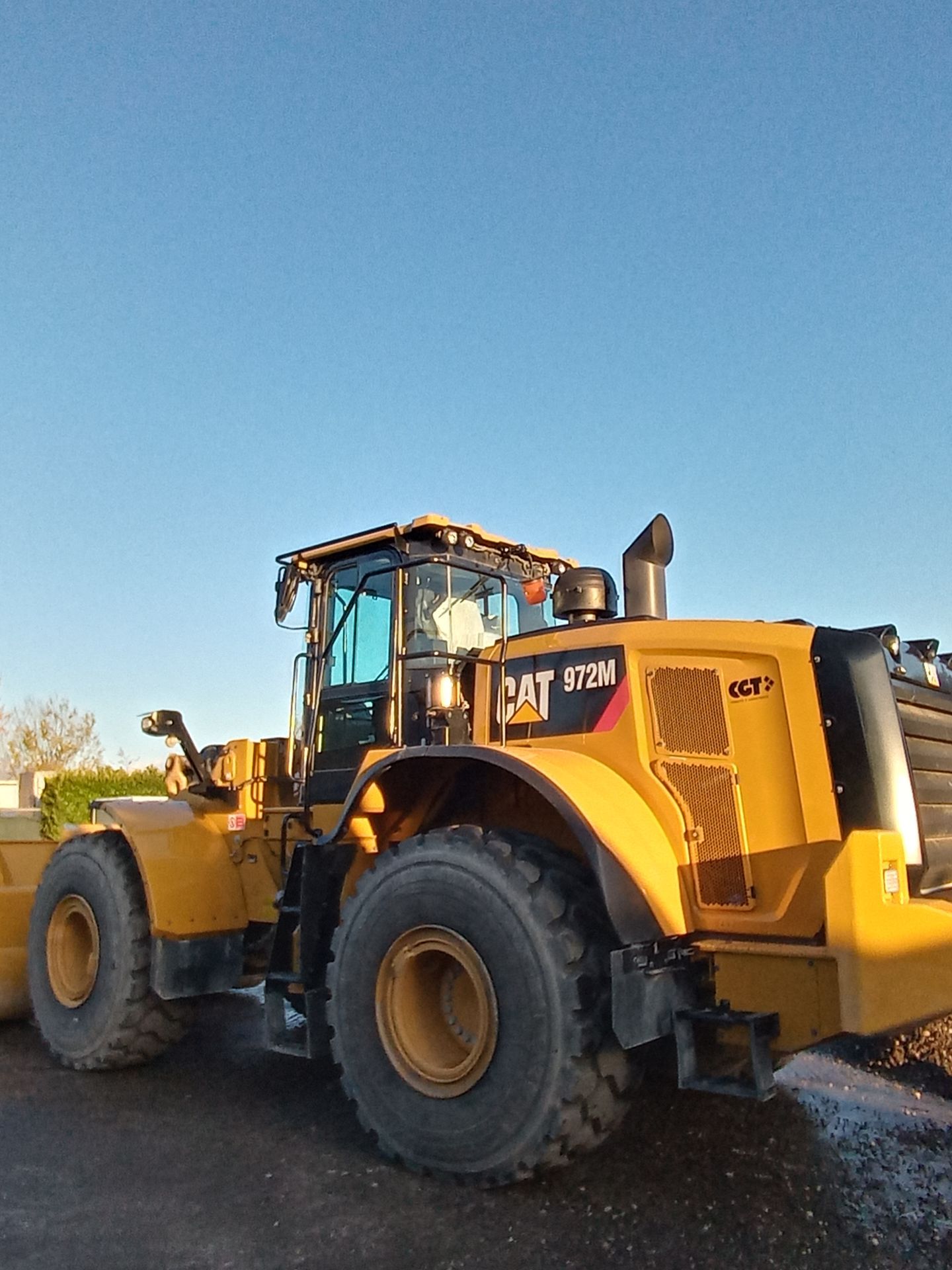 Un trattore gatto giallo è parcheggiato in un parcheggio