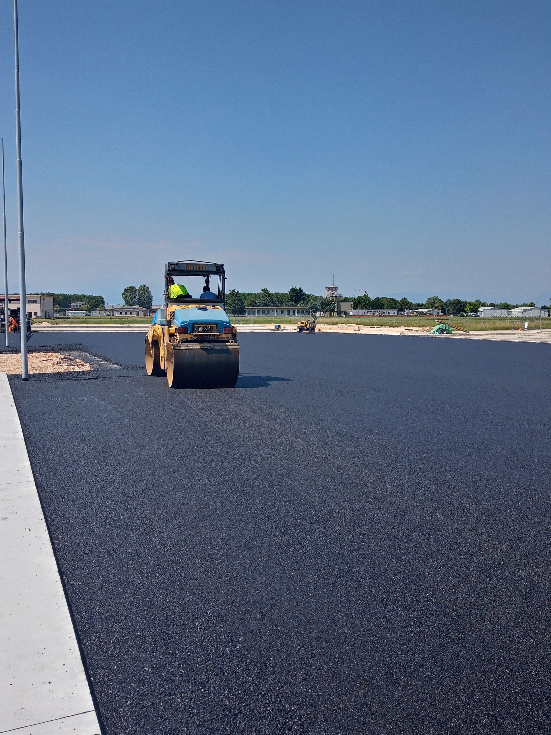 Un rullo fa rotolare l'asfalto su una strada.