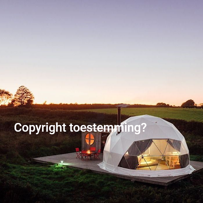 Glamping-unit in een geodetische koepel op een grasveld bij schemering; buiten zitgelegenheid met vuurplaats.