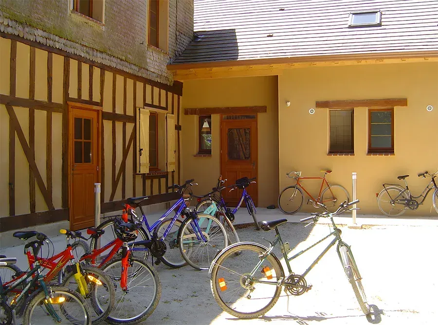 Een tafereel bij het zwembad met een terras, een ligstoel onder een parasol en het water dat erin weerspiegelt.