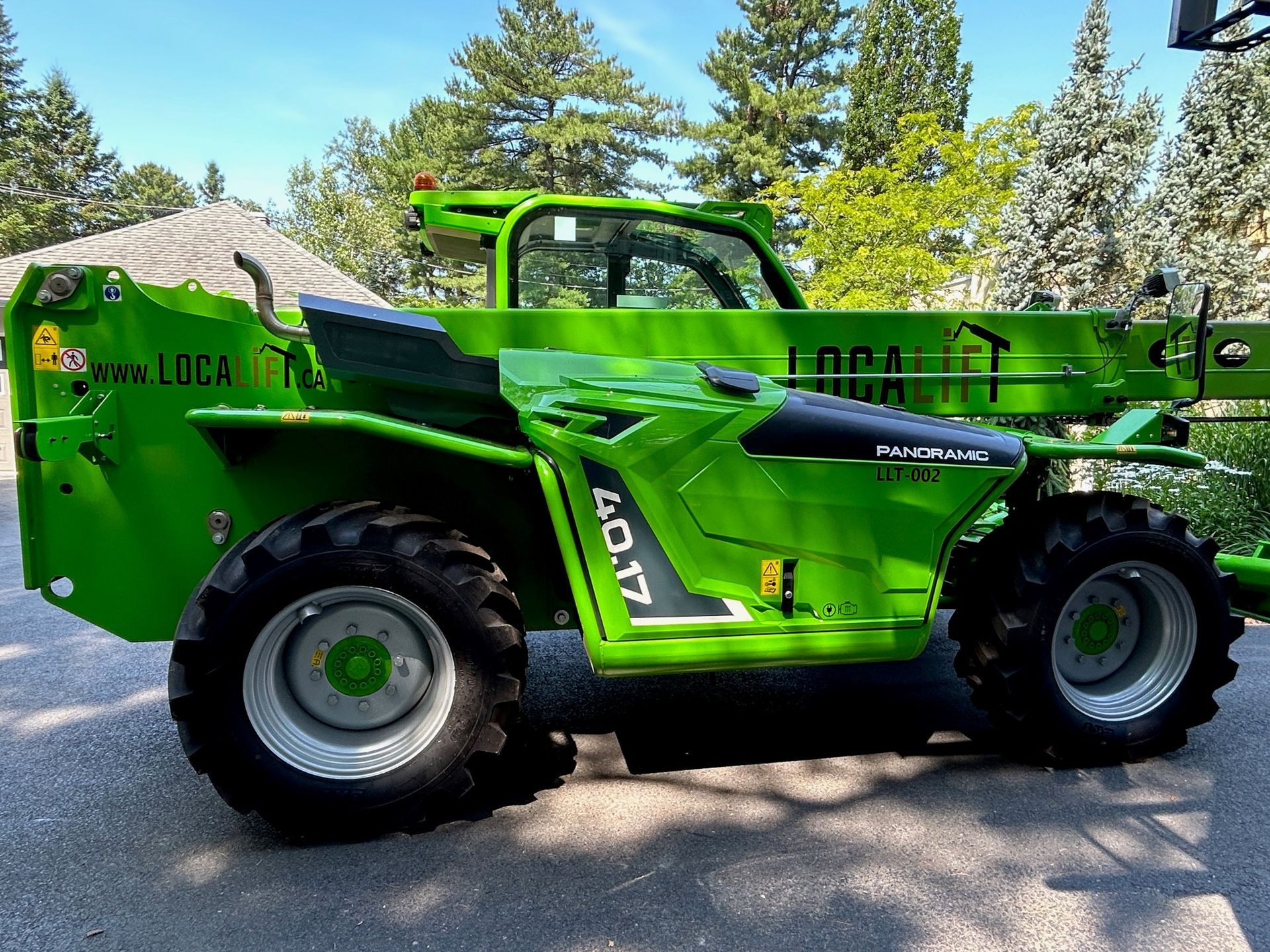Un chariot élévateur vert est garé sur le bord de la route.