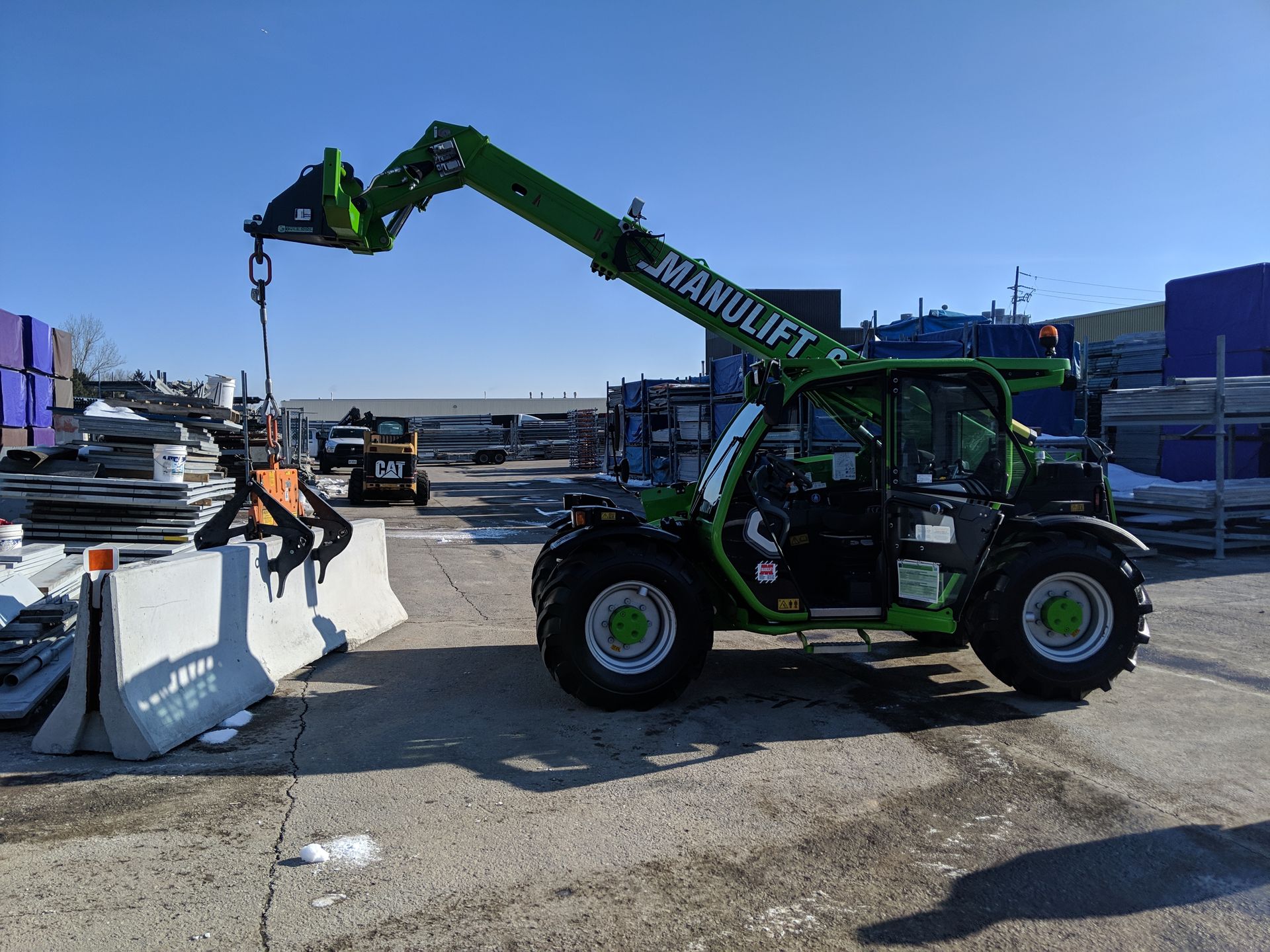 Un chariot élévateur vert est garé sur un parking.