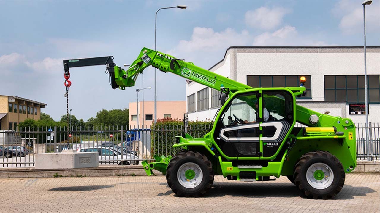 Un chariot élévateur vert est garé devant un bâtiment.