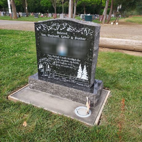 A gravestone with a black cross on it