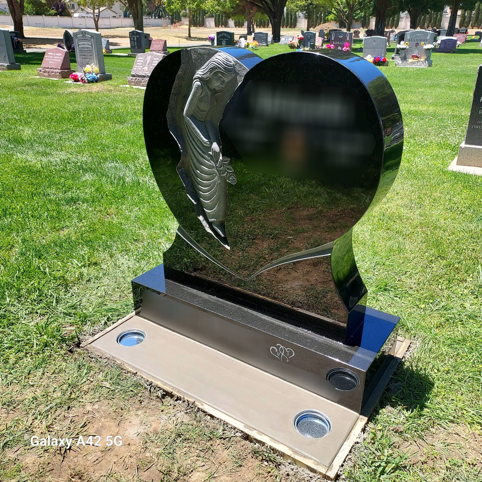A vase of flowers is sitting on top of a grave.
