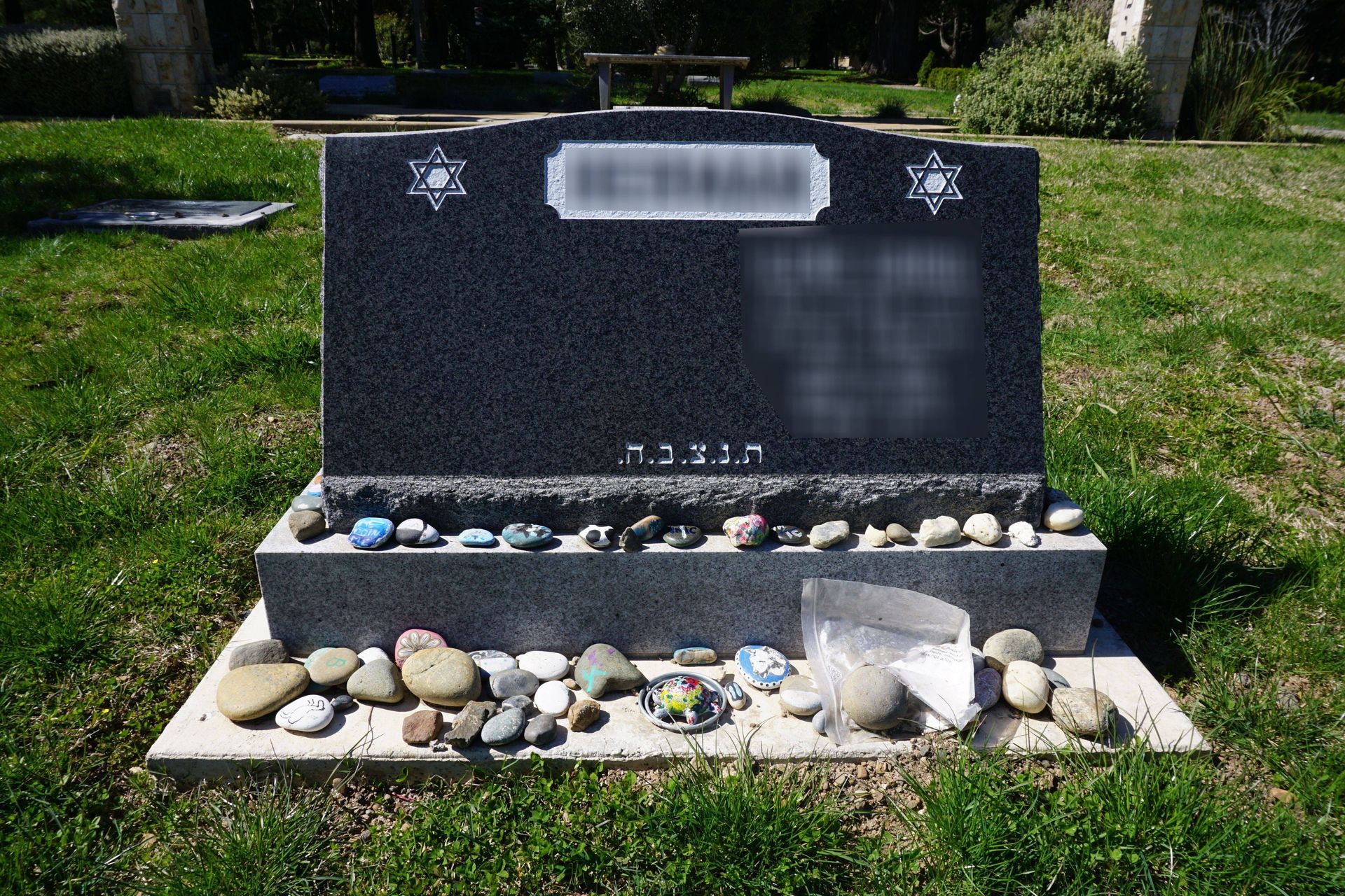 A gravestone with two vases of flowers in a cemetery.