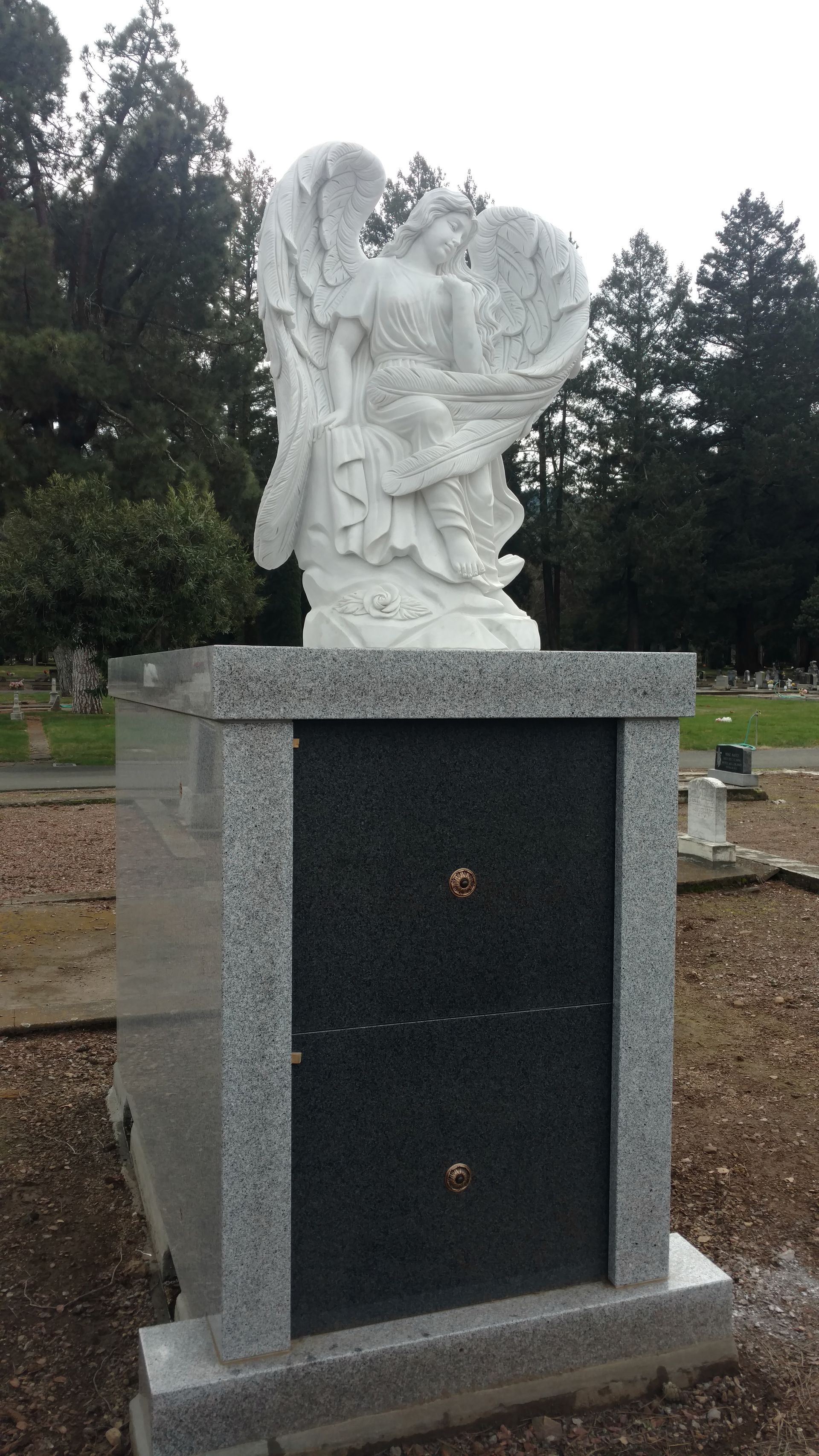 A person is putting flowers on a grave in a cemetery.