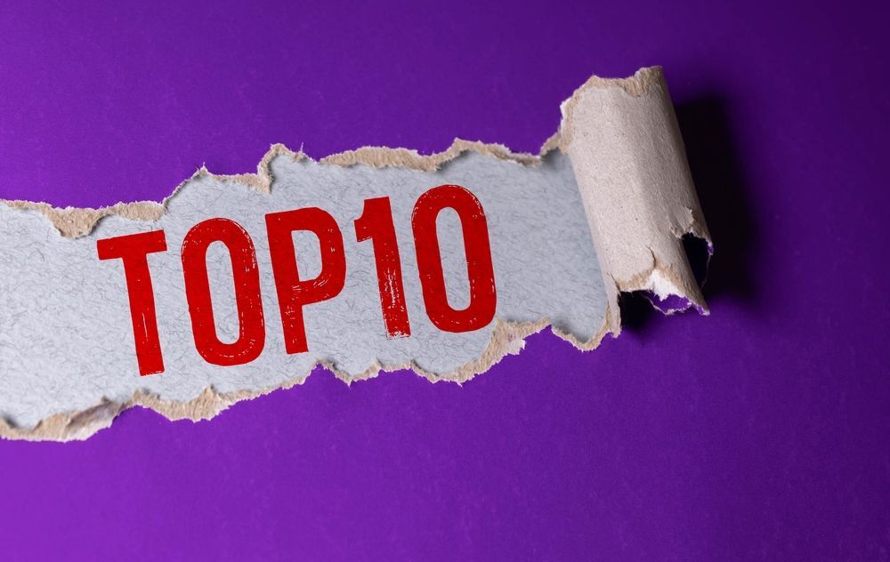 A piece of torn paper with the word top 10 written on it.