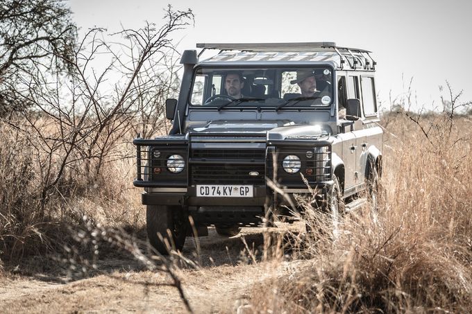 Land Rover safari 4x4 vehicle driving through african bush