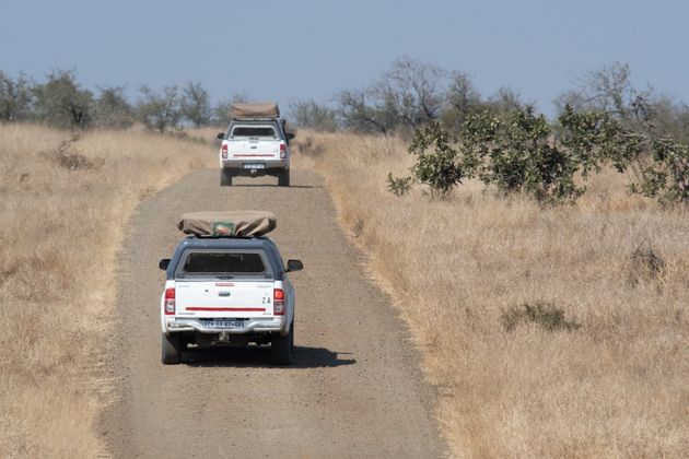 Two equipped safari 4x4 vehicles driving along dirt road in the south african bush