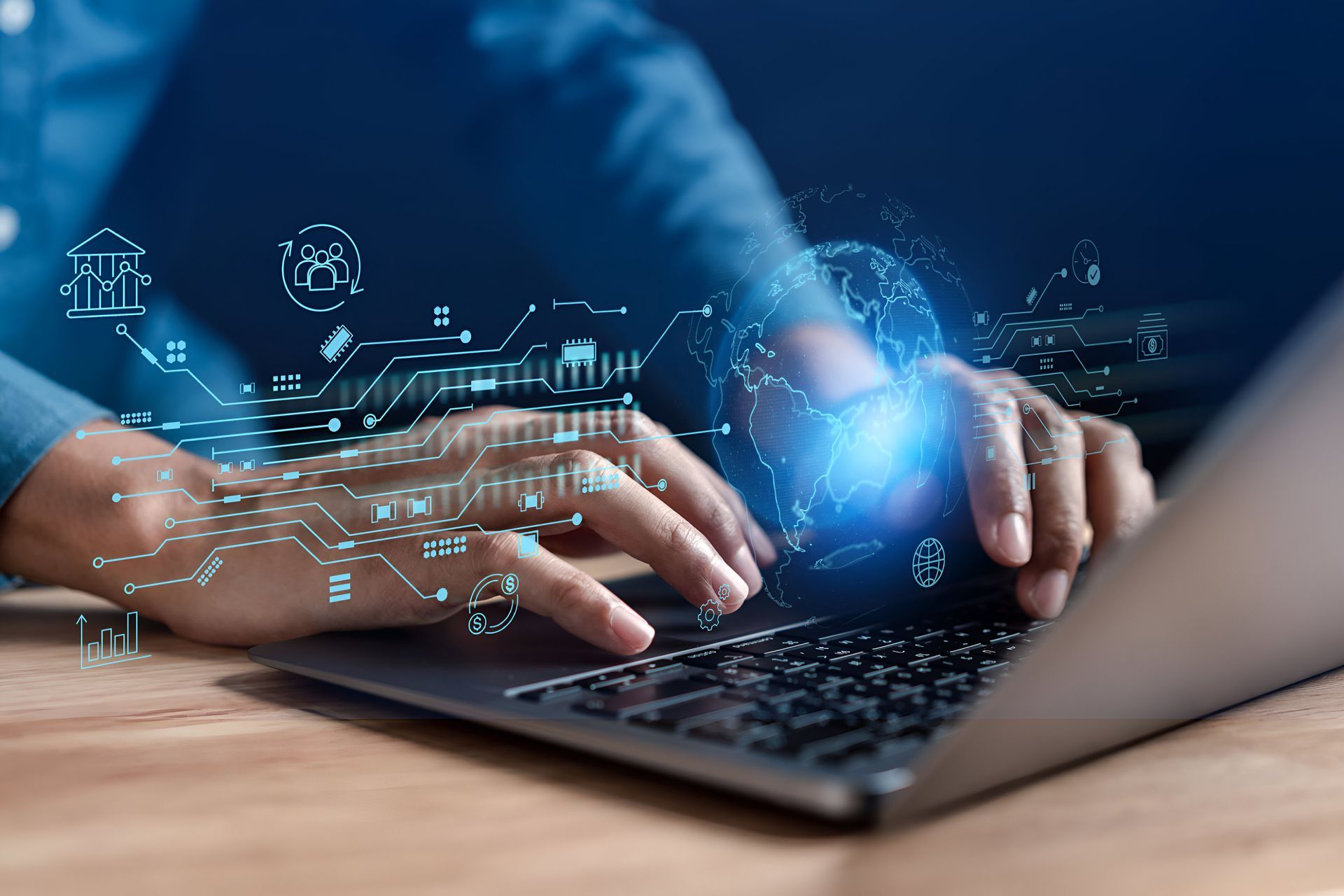 Hands typing on a laptop with a digital holographic overlay of a globe and data network icons.