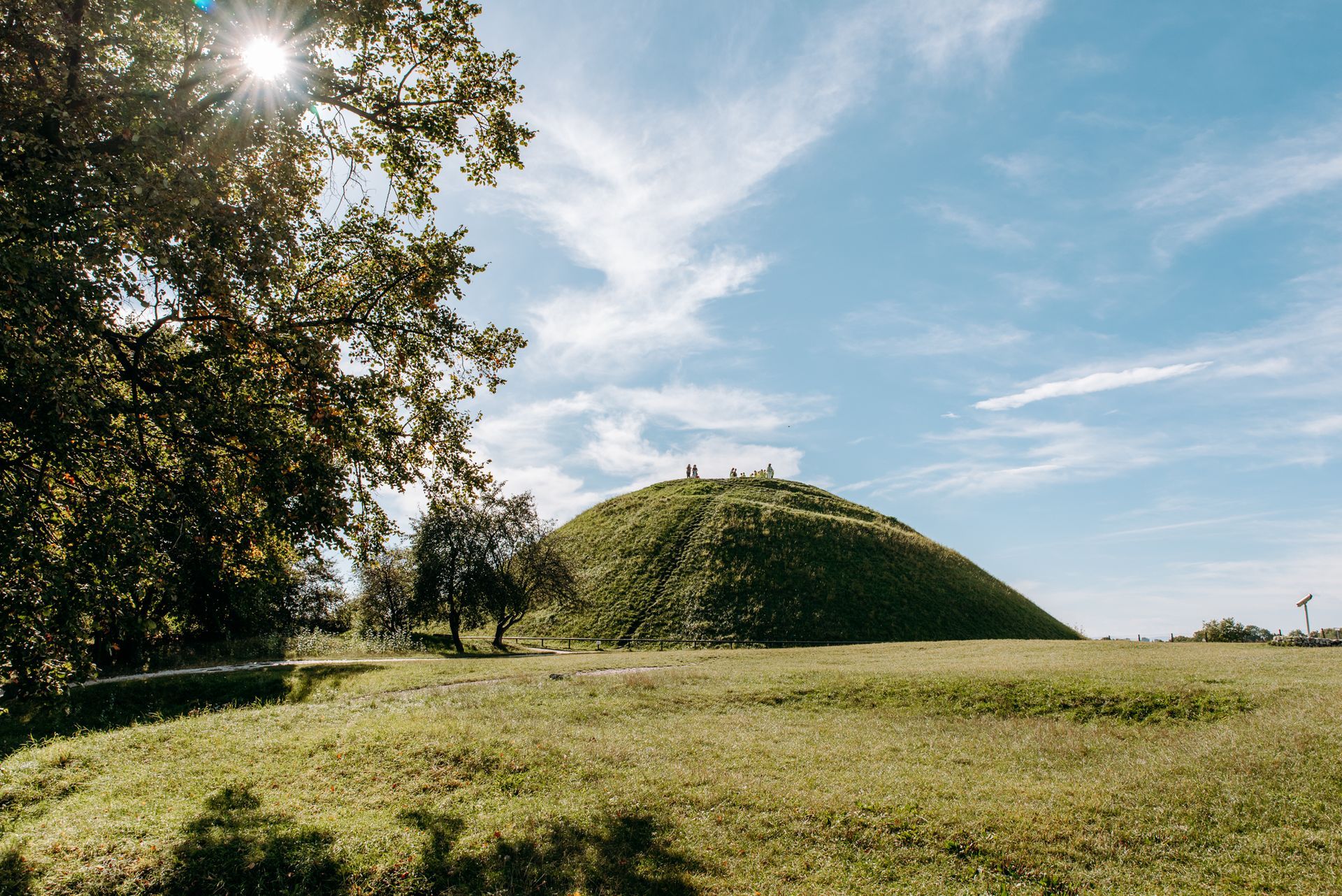 Krakus mound covered in green grass, blue sky in the background.