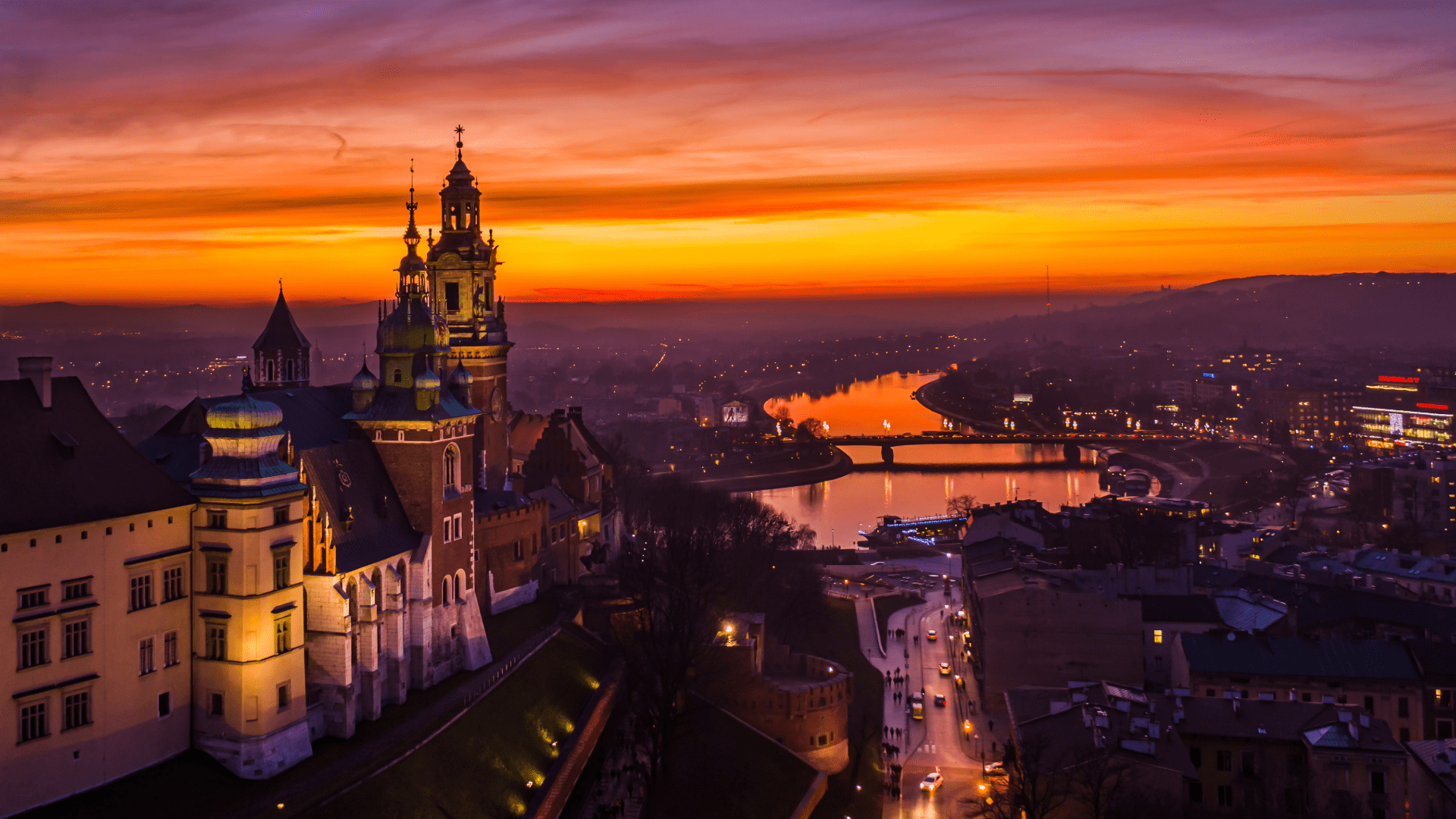 Sunset view over Kraków’s historic buildings and river with a colorful sky