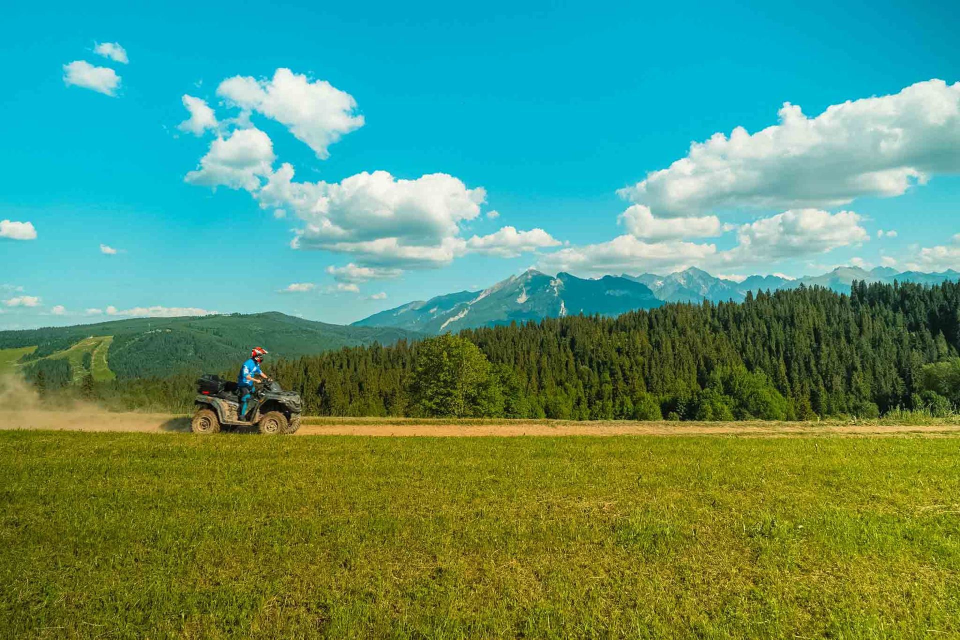 Couple riding on one quad with beautiful view on mountains.