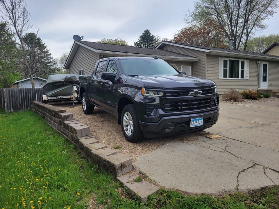 A black truck is parked in front of a house.