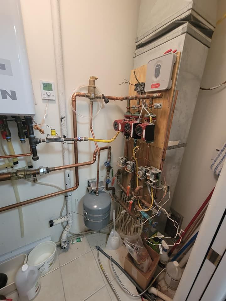 A room with a lot of pipes and wires on the wall.