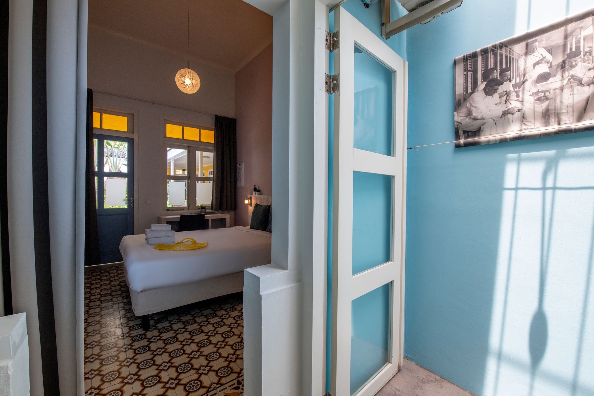 A bedroom with a bed and a door that is open. t Klooster Hotel Curacao