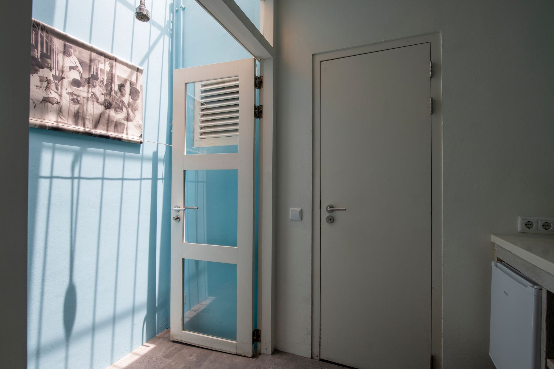 A room with a white door and a blue wall. t Klooster Hotel Curacao