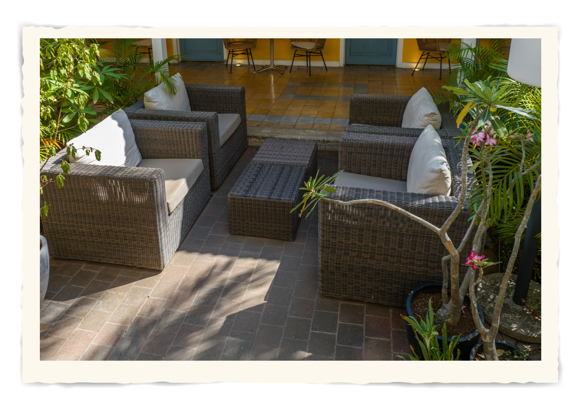 A patio with wicker furniture and a tablet Klooster Hotel Curacao