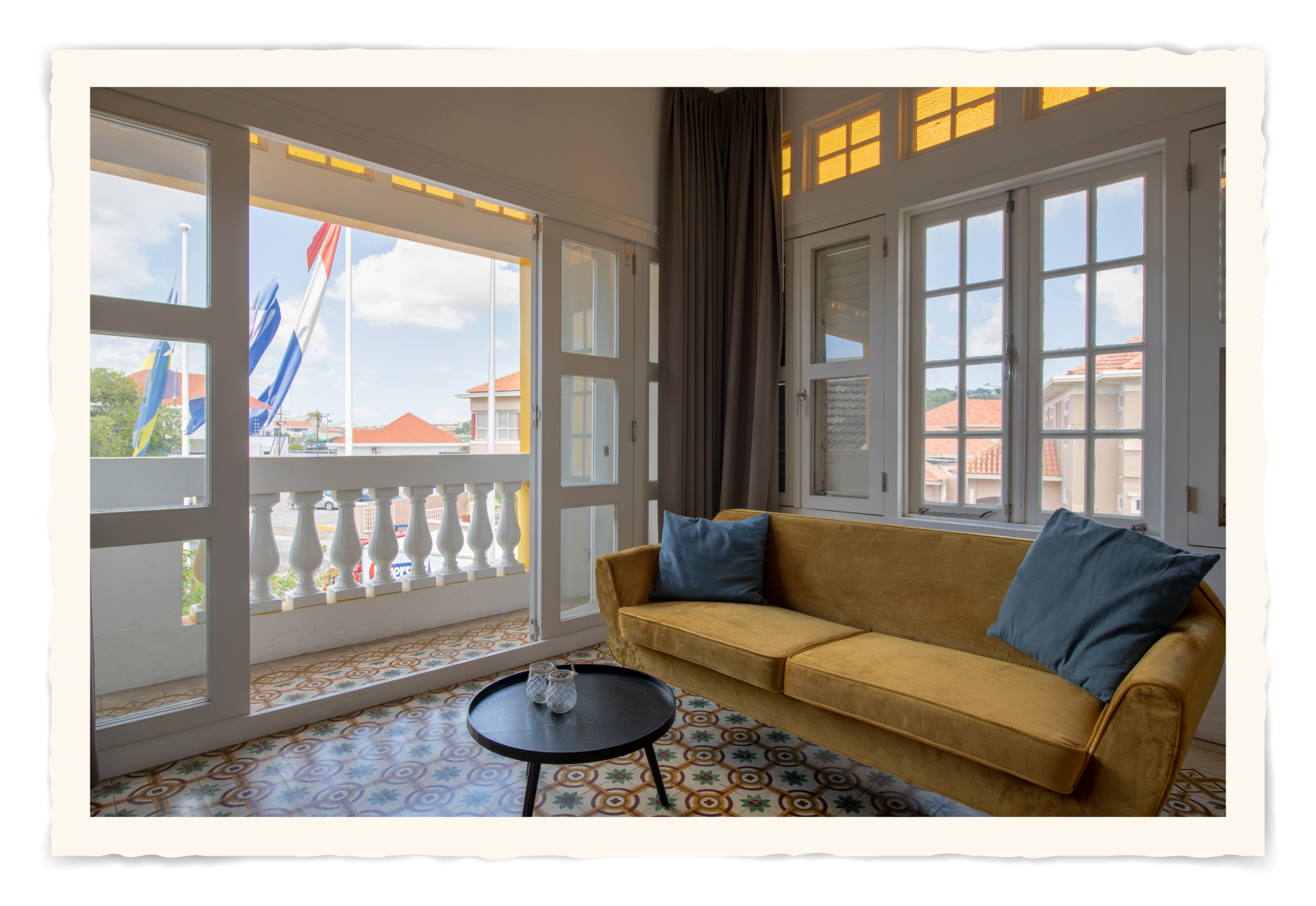 A living room with a yellow couch and a balcony.