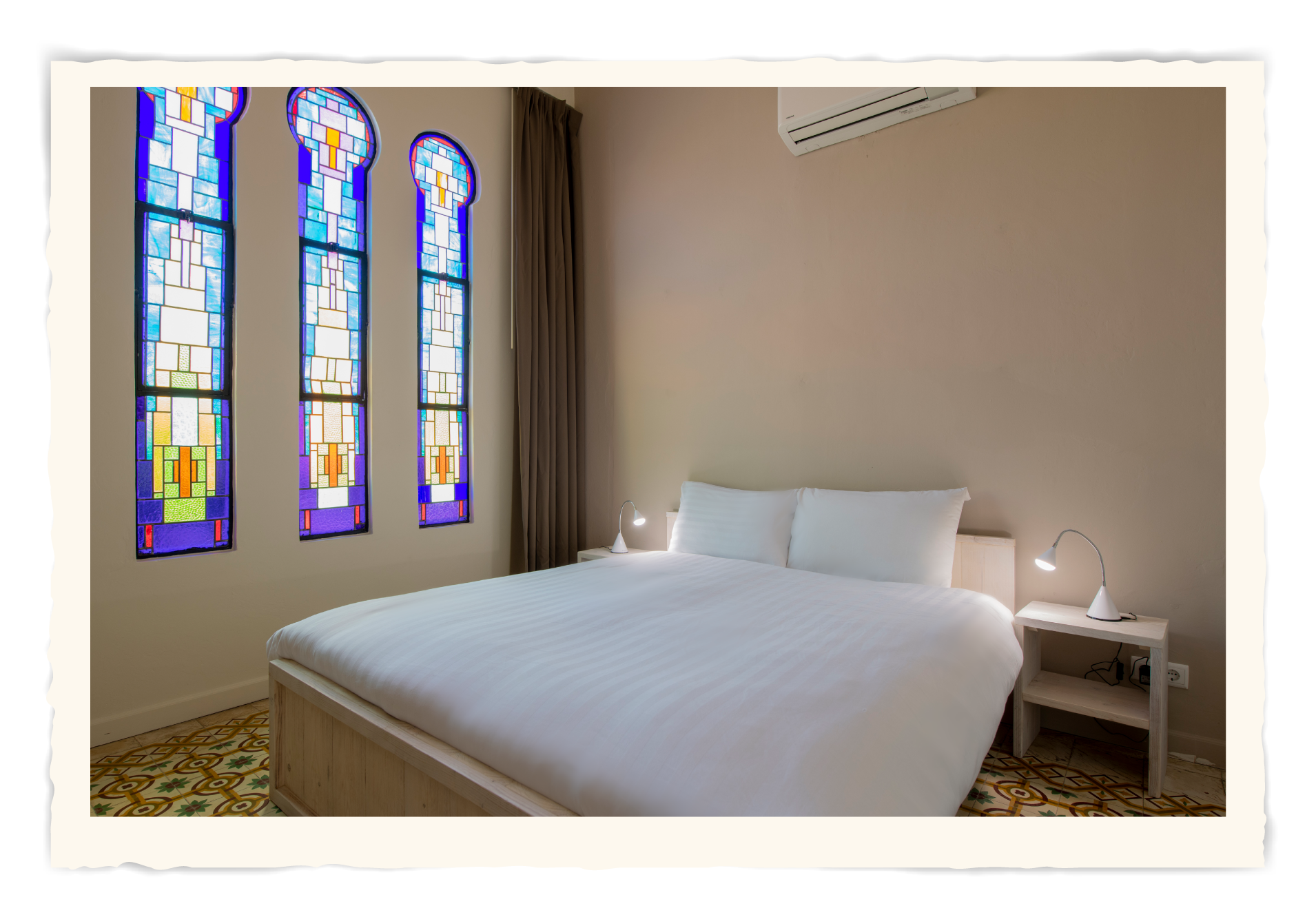 A bedroom with a bed and stained glass windows.t Klooster Hotel Curacao