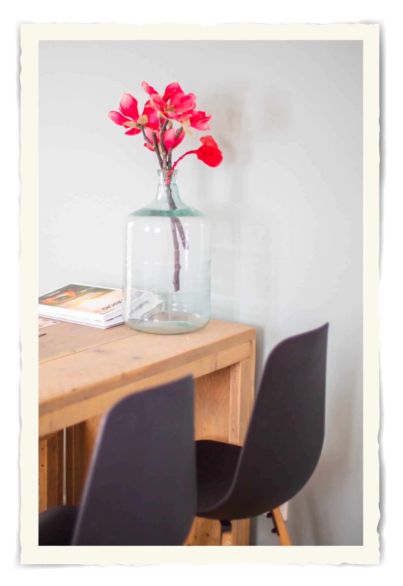 A vase of flowers is sitting on a wooden table next to two chairs.t Klooster Hotel Curacao